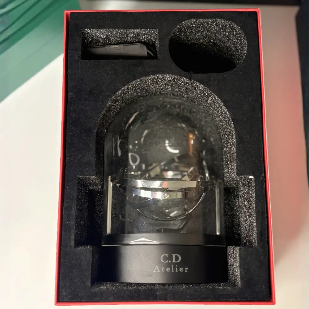 Remontoir gyroscopique pour montre automatique en verre et acier - en situation sur un bureau